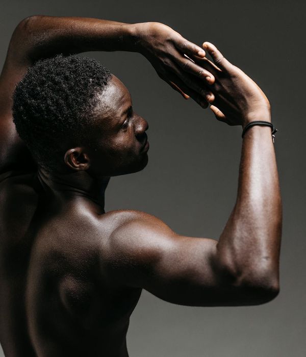 Person doing mindful body movements in dark blue studio