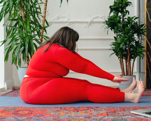 Person practicing meditation and stretching at home